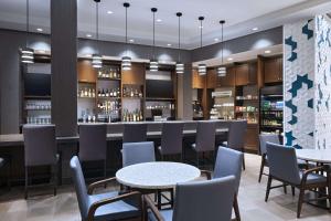a bar in a restaurant with tables and chairs at Hyatt Place Greensboro Downtown in Greensboro