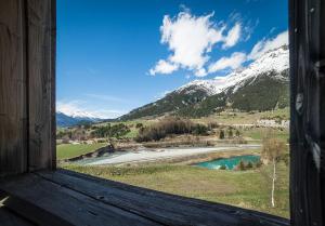 una ventana con vistas al río y a las montañas nevadas en Les Terrasses de Termignon - Val-Cenis, en Termignon