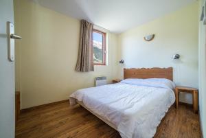 1 dormitorio con cama y ventana en Les Terrasses de Termignon - Val-Cenis, en Termignon