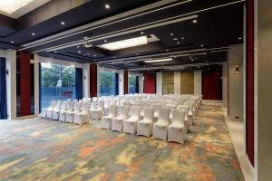 ein leeres Auditorium mit weißen Stühlen in einem Raum in der Unterkunft Svenska Design Hotel Kakinada in Kakinada + 42 Fotos