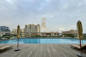 uma piscina com duas cadeiras e dois guarda-sóis em Palm View East Jumeira - Studio Apartment em Dubai