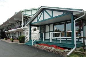 un edificio azul con flores delante en Super 8 by Wyndham Gananoque - Country Squire Resort, en Gananoque