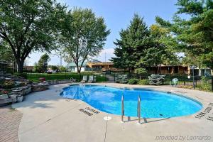 a large swimming pool in a yard with trees at Super 8 by Wyndham Gananoque - Country Squire Resort in Gananoque