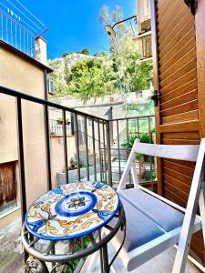 a balcony with a table and a chair at Casa le Maioliche by Housilia in Cefalù