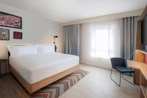 a hotel room with a bed and a chair at Hampton By Hilton Celle in Celle