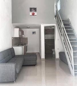 a living room with a couch and a staircase at Elvi Apartment 4 in Rakhónion