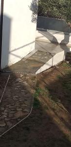 a stone walkway next to a white building at Elvi Apartment 4 in Rakhónion