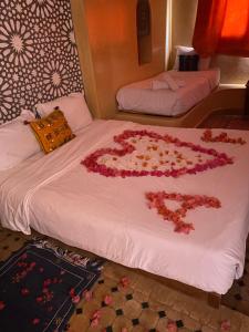 a bed with a heart made out of flowers on it at Dar Rio Oro in Dakhla