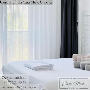 Una cama blanca con toallas encima. en Casa Micle en Craiova