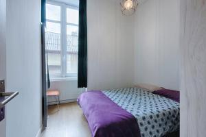 Schlafzimmer mit einem Bett und einem Fenster in der Unterkunft T3 hypercentre proche gare in Bourgoin