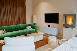 a living room with a green couch and a tv at Casa Alta in Namur