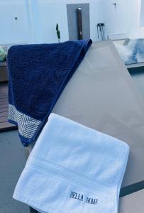 białe łóżko z niebieskim ręcznikiem w obiekcie Bella Home w mieście Garachico