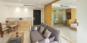 een woonkamer met een bank en een keuken bij Luxurious Botanica Khao Yai in Khao Yai