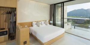 een slaapkamer met een wit bed en een groot raam bij Luxurious Botanica Khao Yai in Khao Yai