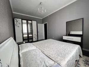 1 dormitorio con 1 cama grande y espejo en ЖК Алмалы, напротив Алматы Арены 81-90 en Almaty