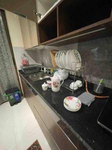a kitchen counter with cups and dishes on it at Endora homestay - A fully equipped lake-facing 3BHK in Lavasa