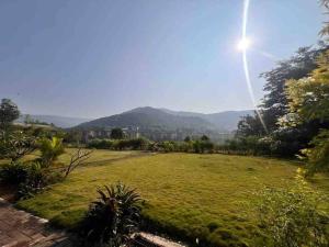 a large field of grass with the sun in the sky at Endora homestay - A fully equipped lake-facing 3BHK in Lavasa