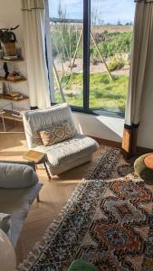 ein Wohnzimmer mit einem Sofa und einem großen Fenster in der Unterkunft Villa Brunelle, Vue bords de Rance in Le Minihic-sur-Rance