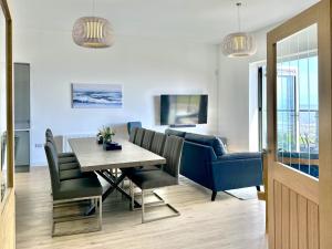 a living room with a table and a blue couch at Shoreside Villa, by the Golf Course in Bridlington
