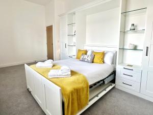 a bedroom with a large white bed with yellow pillows at Shoreside Villa, by the Golf Course in Bridlington +83 photos