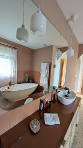 Villa Brunelle, Vue bords de Rance في Le Minihic-sur-Rance: حمام مع حوض كبير ومغسلة