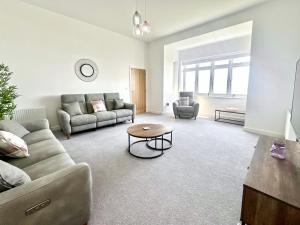 a living room with a couch and a table at Shoreside Villa, by the Golf Course in Bridlington