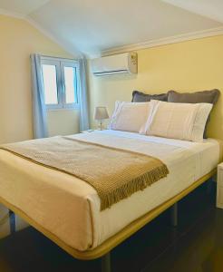 um quarto com uma cama grande e uma janela em Antonella Home Funchal em Funchal