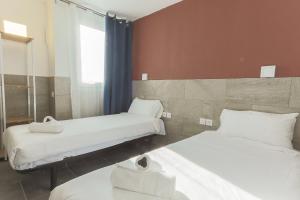Cette chambre comprend 2 lits et une fenêtre. dans l'établissement HOTEL NOCTUEL, à Rambouillet