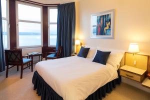 a bedroom with a large bed and a large window at The Cedars Guest House in Dunoon