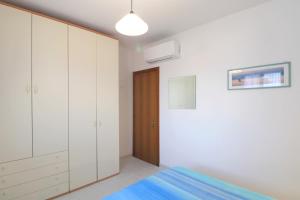 - une chambre avec des placards blancs et un lit bleu dans l'établissement Cà Roby, à Fiumaretta di Ameglia