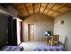 a room with a desk and a chair and a computer at Chalo Daanda Forest Farm, Chamba in Chamba