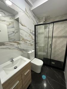 y baño con aseo, lavabo y ducha. en Rooms Mediavilla, en Madrid