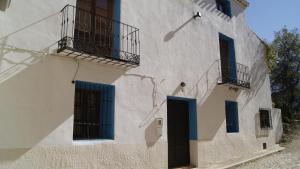 a white building with blue doors and balconies at Casa Rural Tía Victoria in Letur