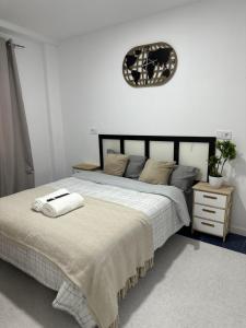 1 dormitorio con 1 cama grande y reloj en la pared en Rooms Mediavilla, en Madrid
