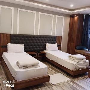 Zimmer mit 2 Betten in einem Zimmer mit Fenstern in der Unterkunft Hotel Trihari in Rishikesh