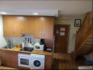 uma cozinha com um lavatório e uma máquina de lavar roupa em apartamento noviembre em Madri