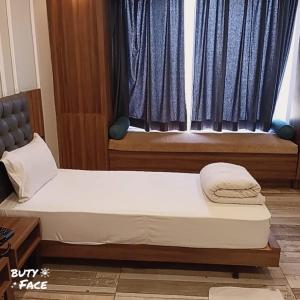 Bett in einem Zimmer mit Fenster in der Unterkunft Hotel Trihari in Rishikesh