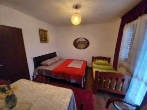 a bedroom with two beds and a table and a mirror at Etno House Mira in Virpazar