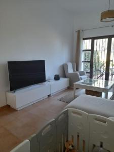 uma sala de estar com uma grande televisão de ecrã plano em Valle Verde Alcaidesa em San Roque