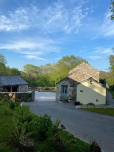 a stone building with a garage in a parking lot at Secluded woodland annex between Mylor and Flushing in Falmouth