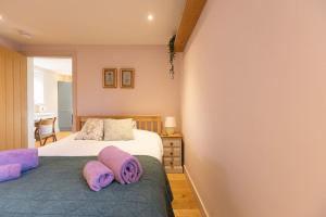 a bedroom with a bed with purple towels on it at Secluded woodland annex between Mylor and Flushing in Falmouth