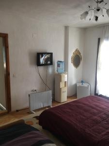 sypialnia z łóżkiem i telewizorem na ścianie w obiekcie Rooms Struga w mieście Struga