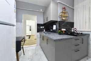 - une cuisine avec des placards blancs et des comptoirs en granit dans l'établissement Center Suite 5, à Istanbul