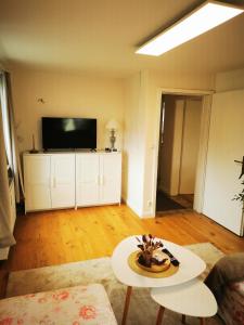 ein Wohnzimmer mit einem TV und einem Tisch in der Unterkunft Kleine Auszeit in Amelinghausen