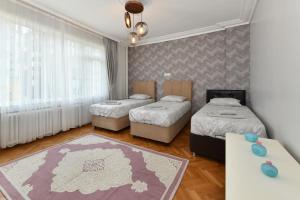 - une chambre avec 3 lits et une table dans l'établissement Center Suite 5, à Istanbul