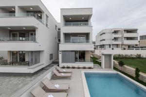 an aerial view of a building with a swimming pool at Apartments Mare B with pool in Novalja