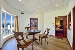 a dining room with a table and chairs and a balcony at Galleu Hill Resort, Kufri Himalayan view resort in Cheog