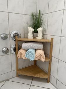 drewniana półka w łazience z ręcznikami i rośliną w obiekcie Ferienwohnung Rosch w mieście Konz