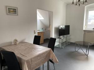 a dining room with a table and a television at Ferienwohnung Rosch in Konz