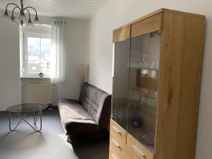 salon z kanapą i szklaną szafką w obiekcie Ferienwohnung Rosch w mieście Konz